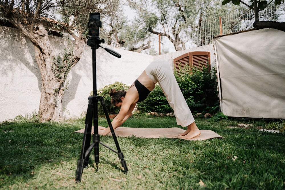 a woman doing a yoga pose in a yard
