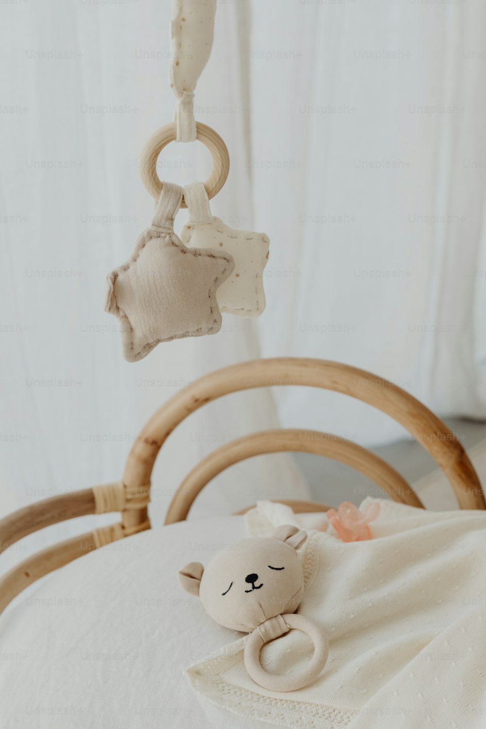 a baby crib with a stuffed animal hanging from it's side