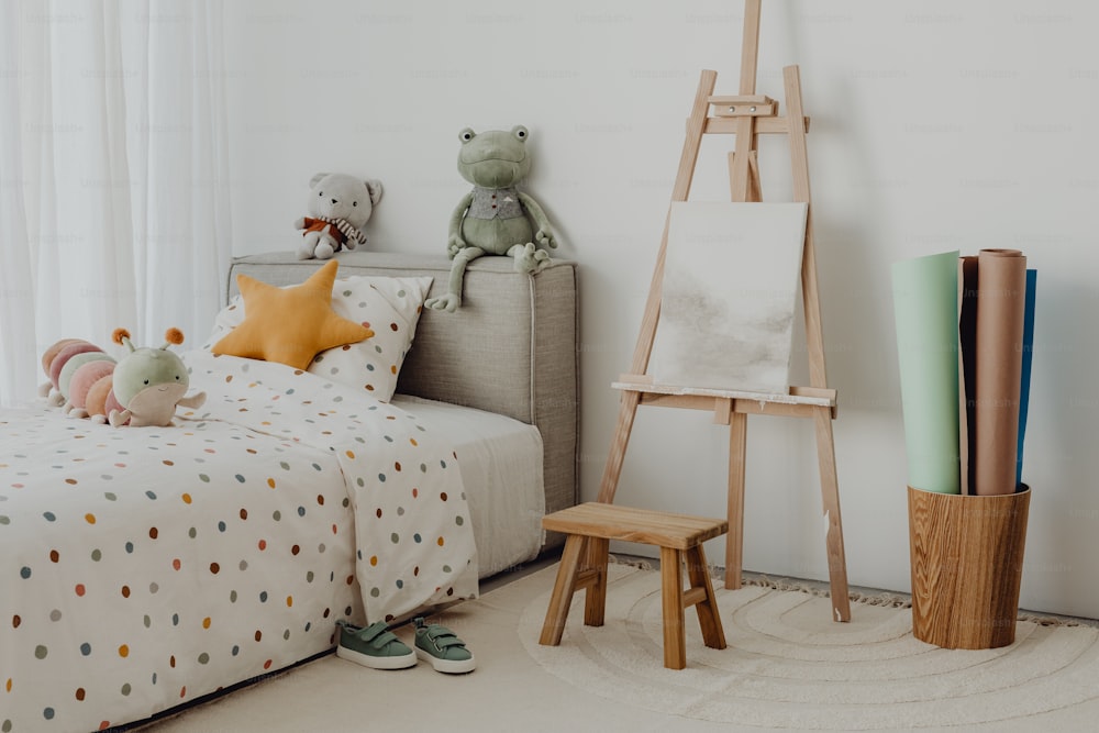 a child's bedroom with a bed and a painting easel