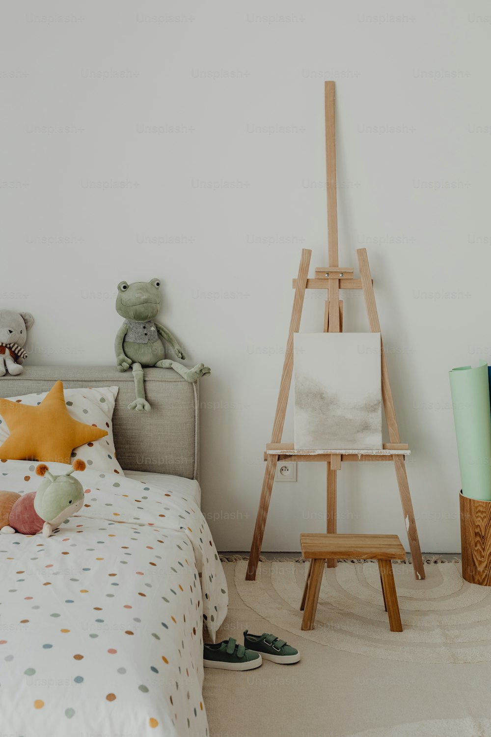 a child's bedroom with a teddy bear and a painting easel