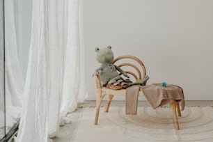 ein frosch, der auf einem stuhl vor einem fenster sitzt