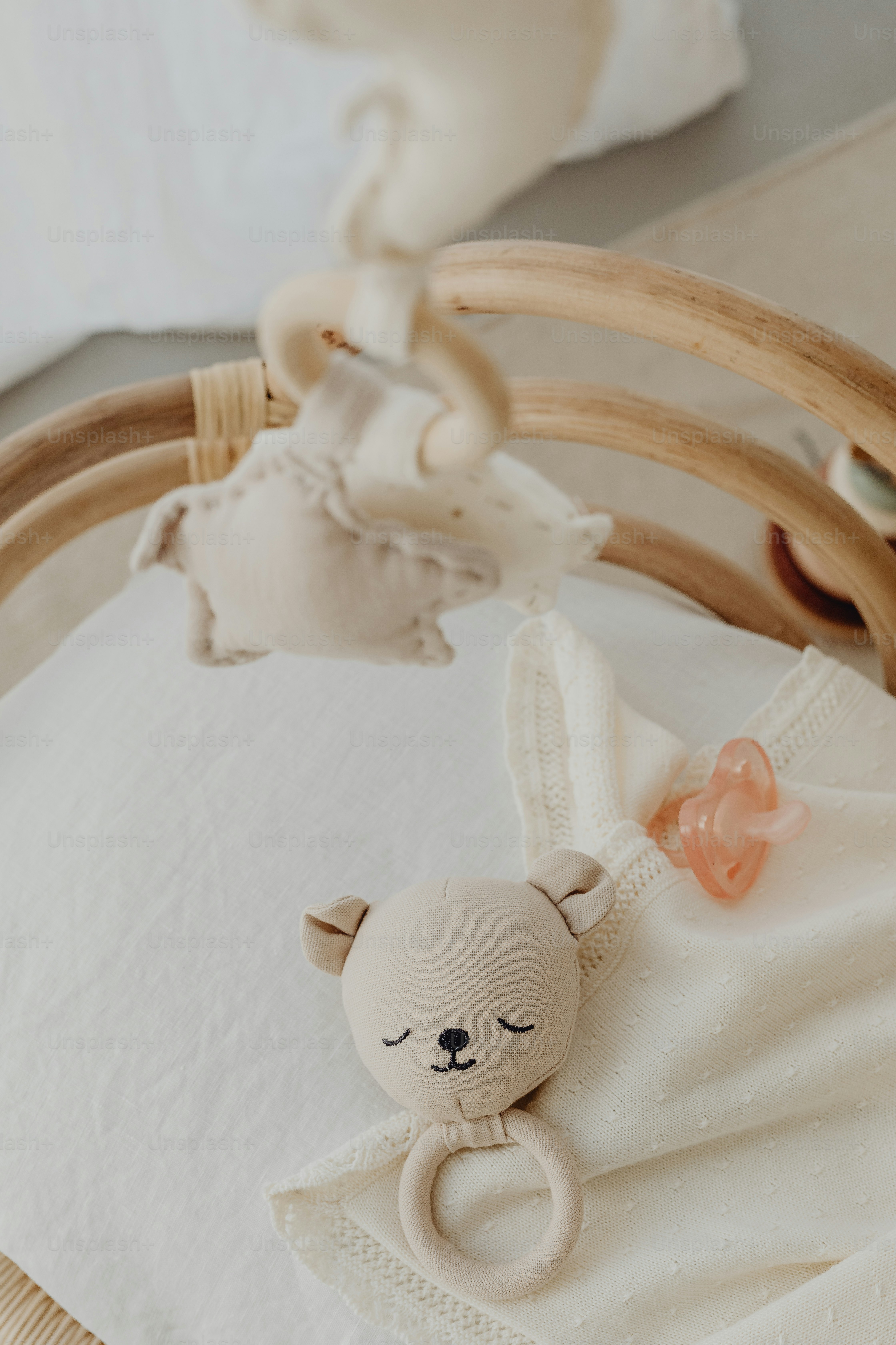 ein Babybett mit einem Stofftier, das an der Seite hängt