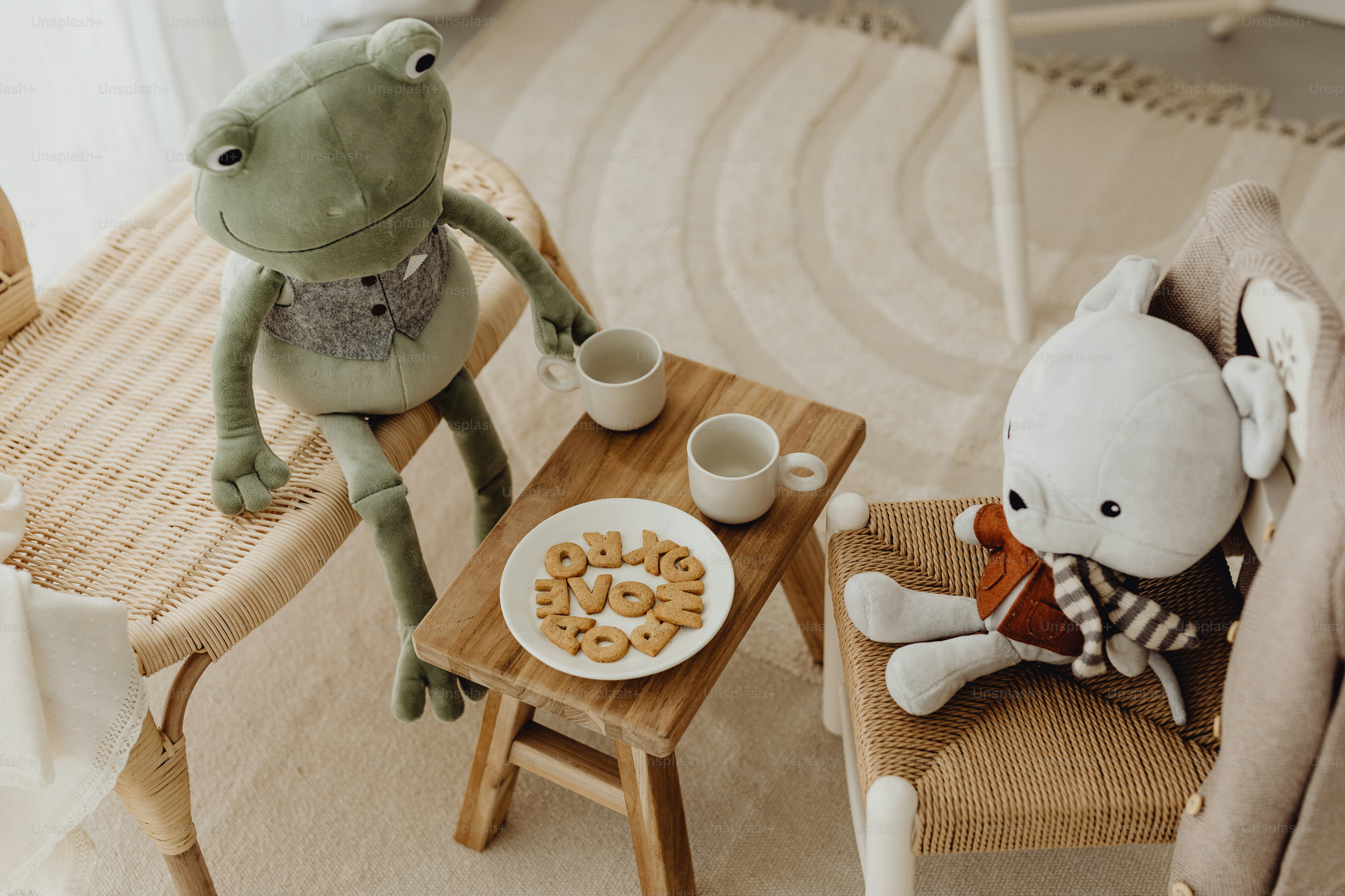 テーブルの横の椅子に座っている2匹のぬいぐるみ
