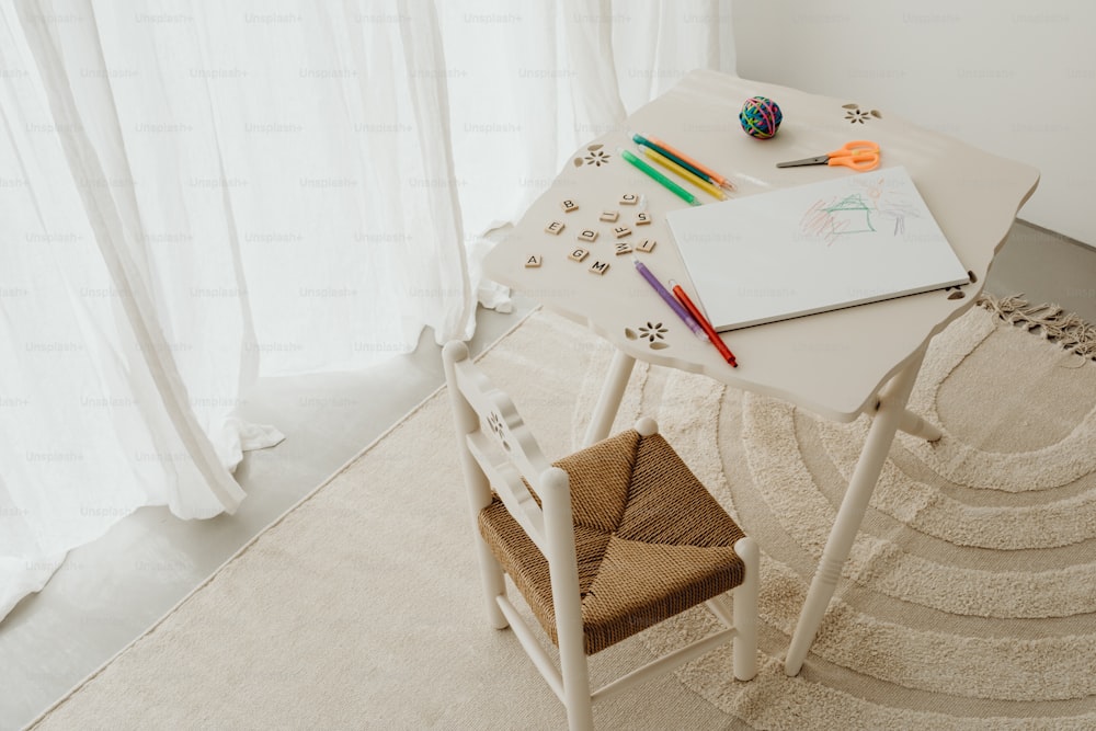 un escritorio blanco con una silla y un dibujo en él