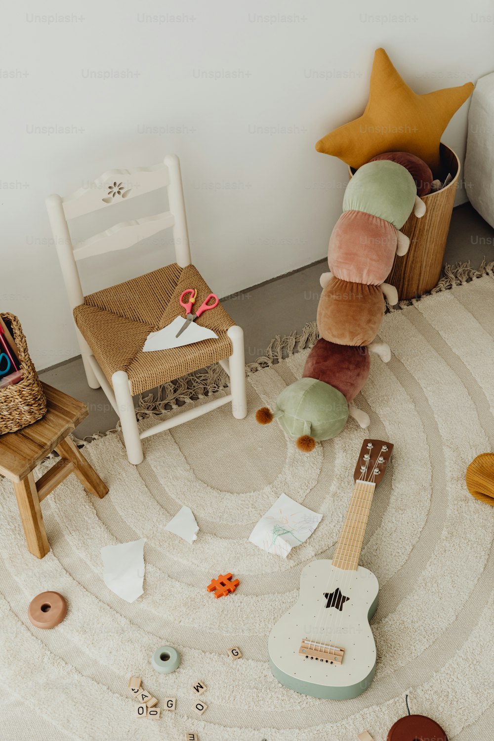 a room with a guitar, chair, and stuffed animal