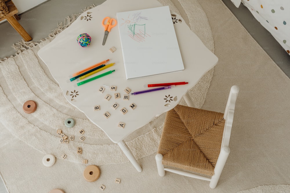 a white table topped with a chair and a notebook