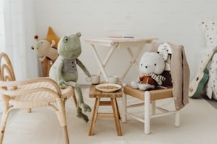 Dos animales de peluche sentados en sillas en la habitación de un niño
