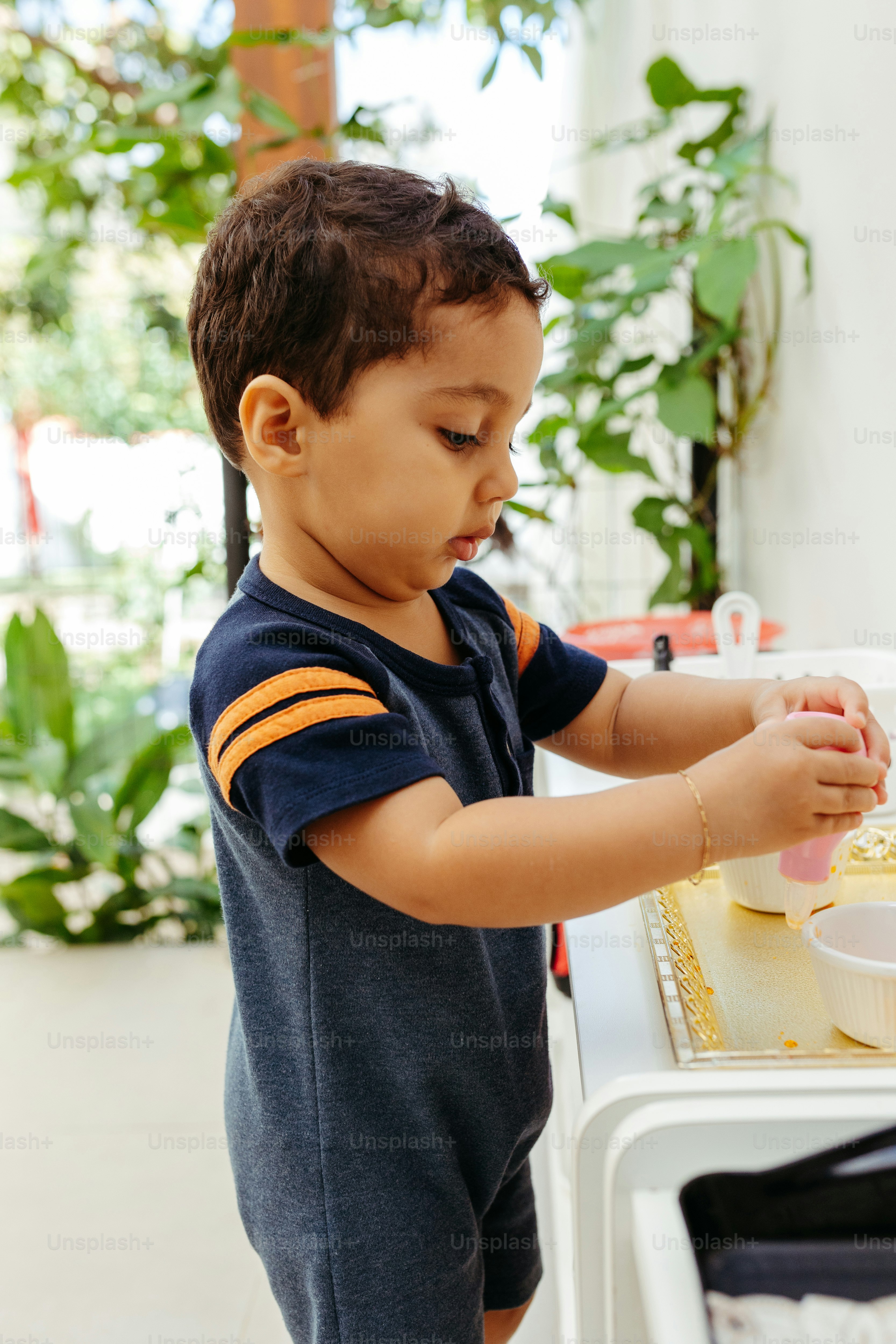 a little boy that is standing in front of a cake