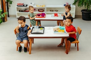 eine gruppe von kindern, die an einem tisch sitzen und essen