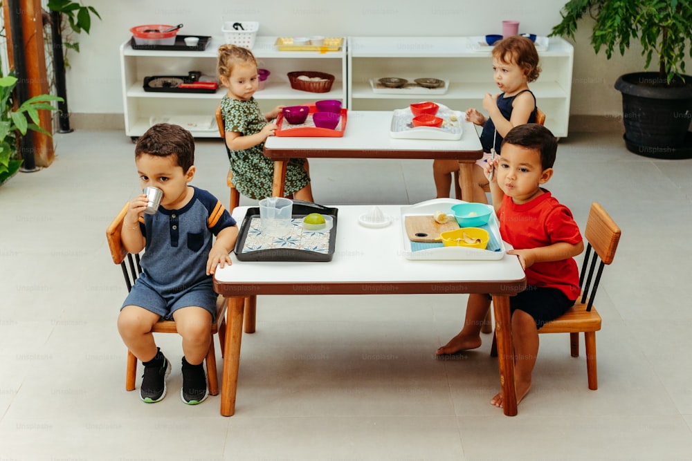 Un grupo de niños sentados en una mesa comiendo