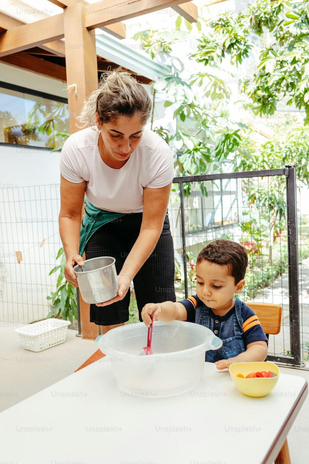 食べ物のボウルで子供を助��ける女性