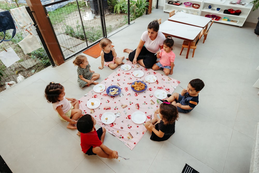 un groupe d’enfants assis autour d’une table en train de manger un gâteau