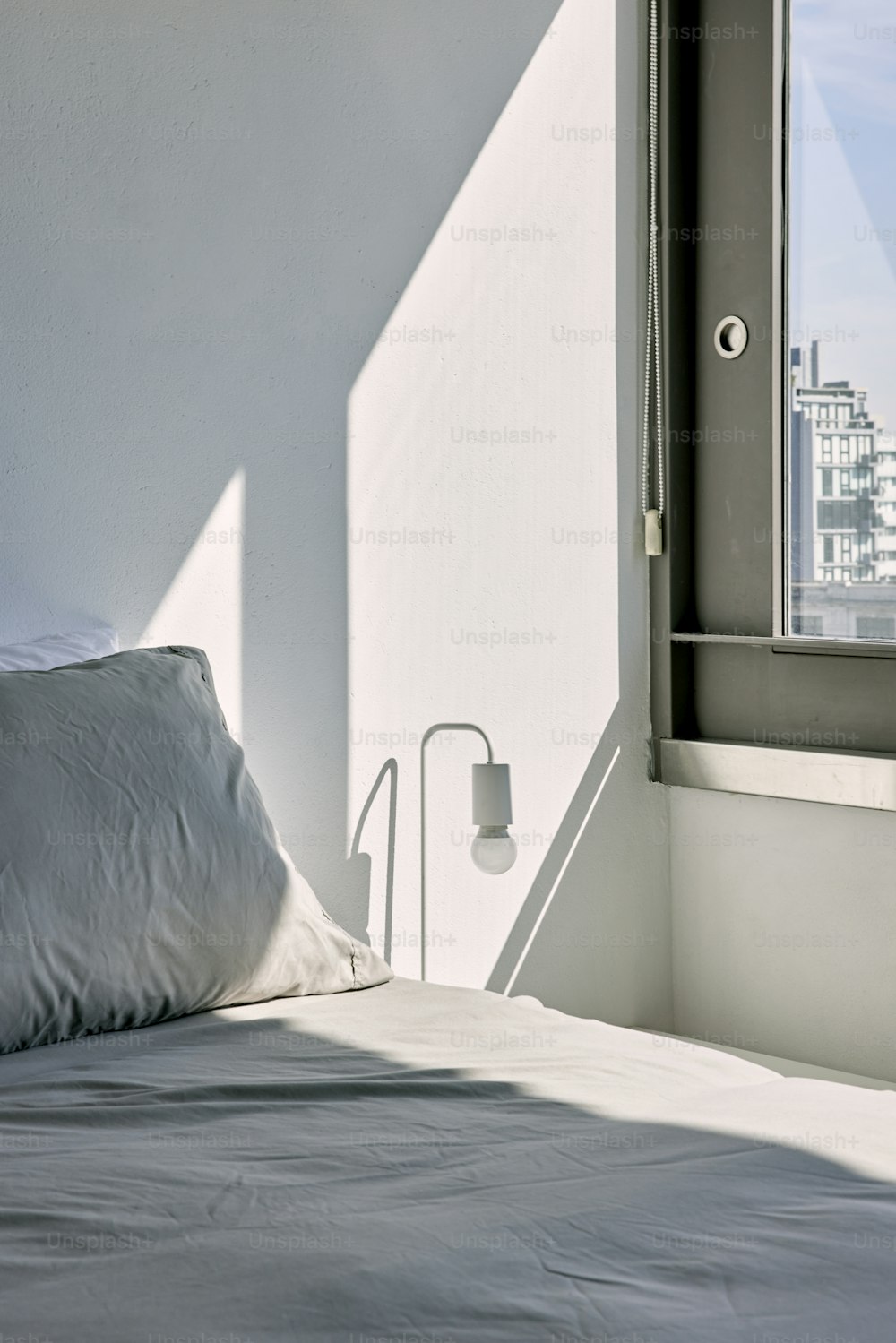 a bed with a white comforter and a window