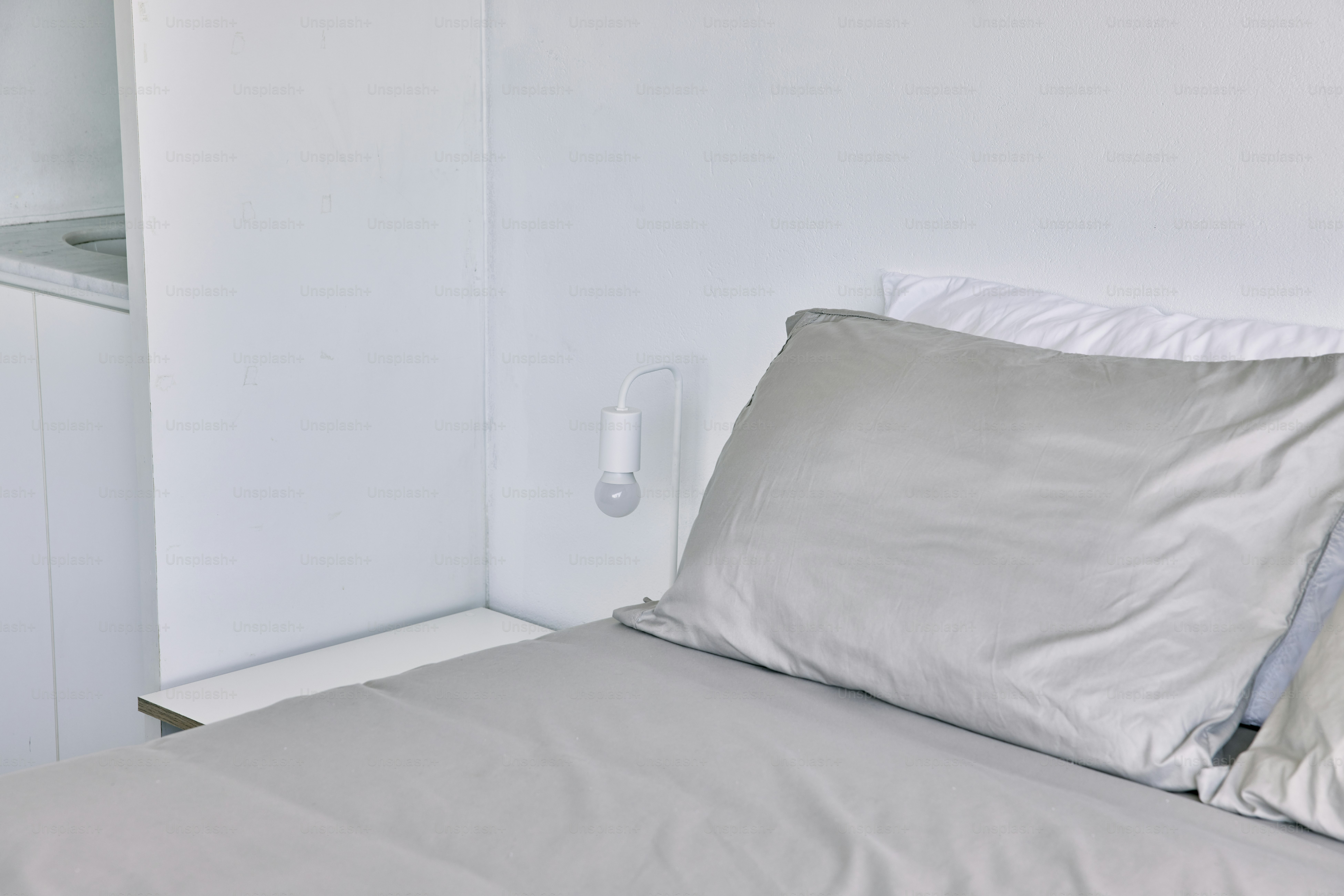 un letto con due cuscini e un comodino