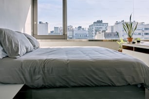 un letto seduto in una camera da letto accanto a una finestra