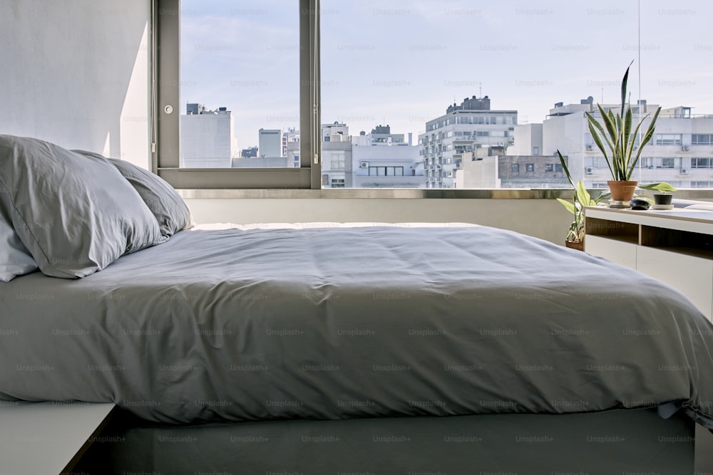 uma cama sentada em um quarto ao lado de uma janela