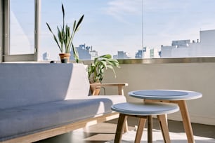 eine Couch und ein Tisch auf einem Balkon mit Blick auf eine Stadt