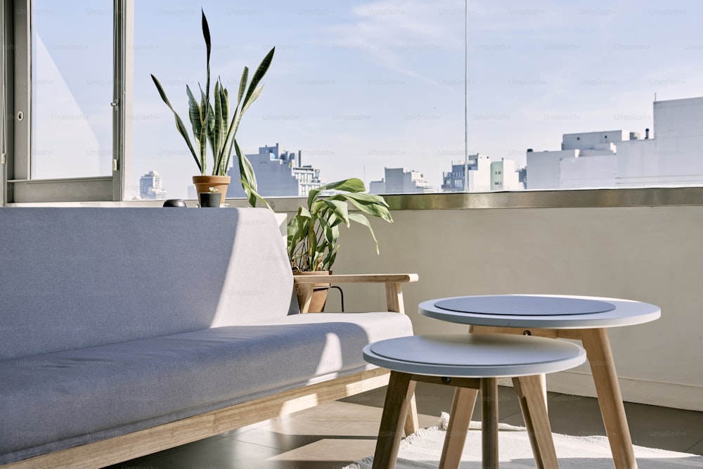 eine Couch und ein Tisch auf einem Balkon mit Blick auf eine Stadt