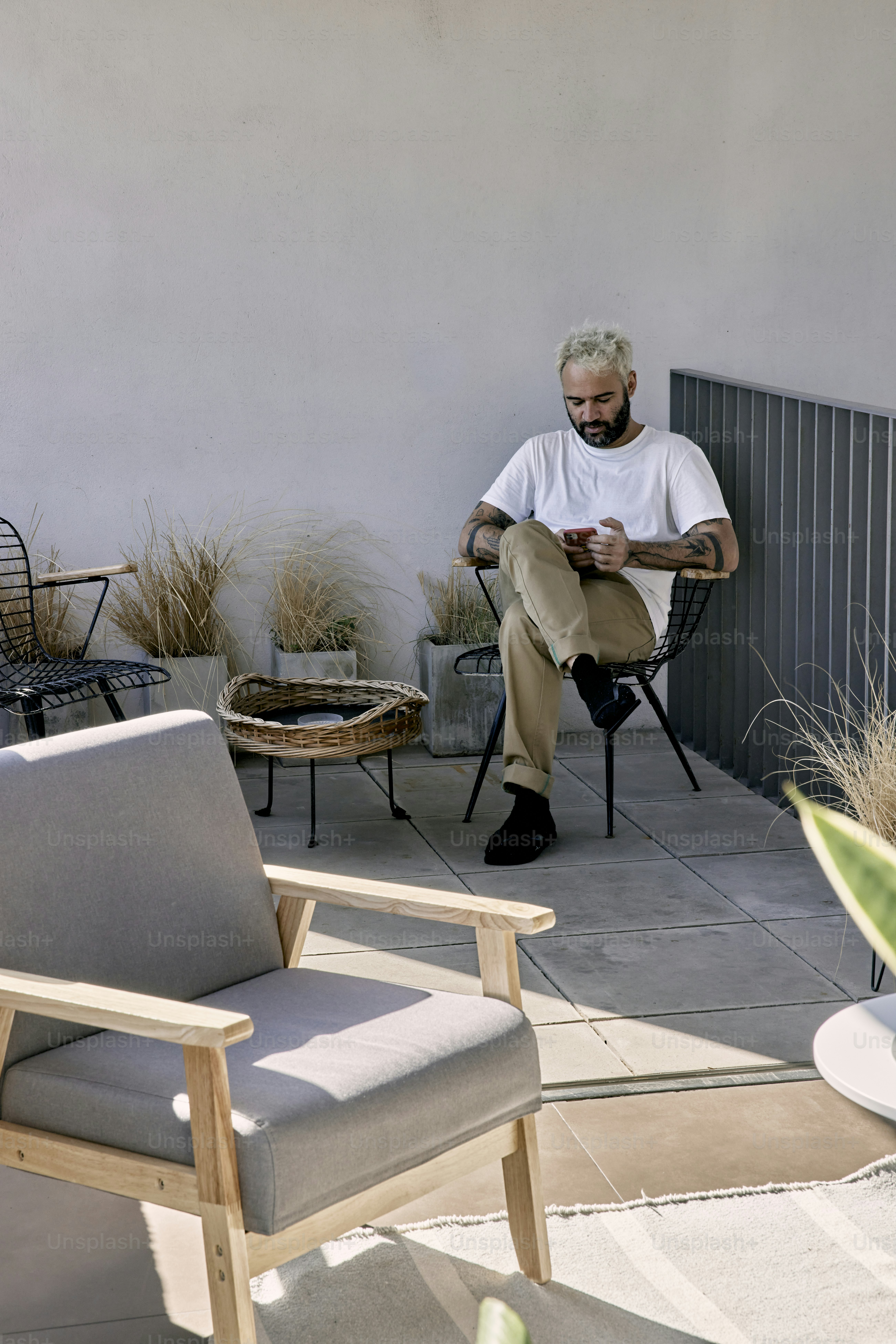 ein mann, der auf einem stuhl sitzt und auf sein handy schaut