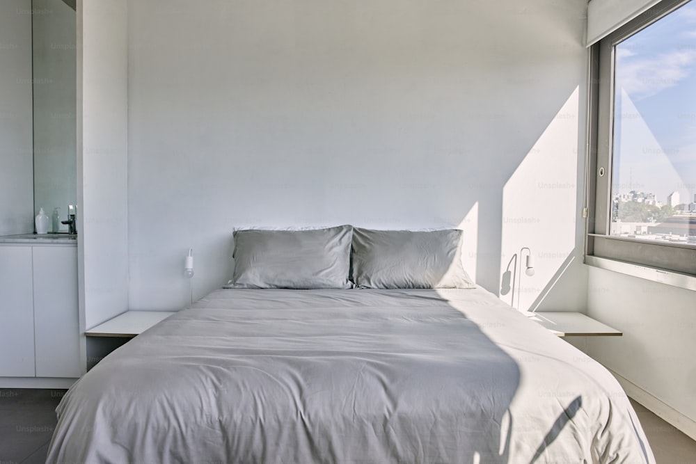 a bed sitting next to a window in a bedroom