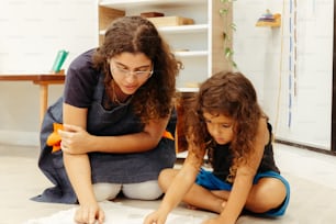 a woman and a child are sitting on the floor