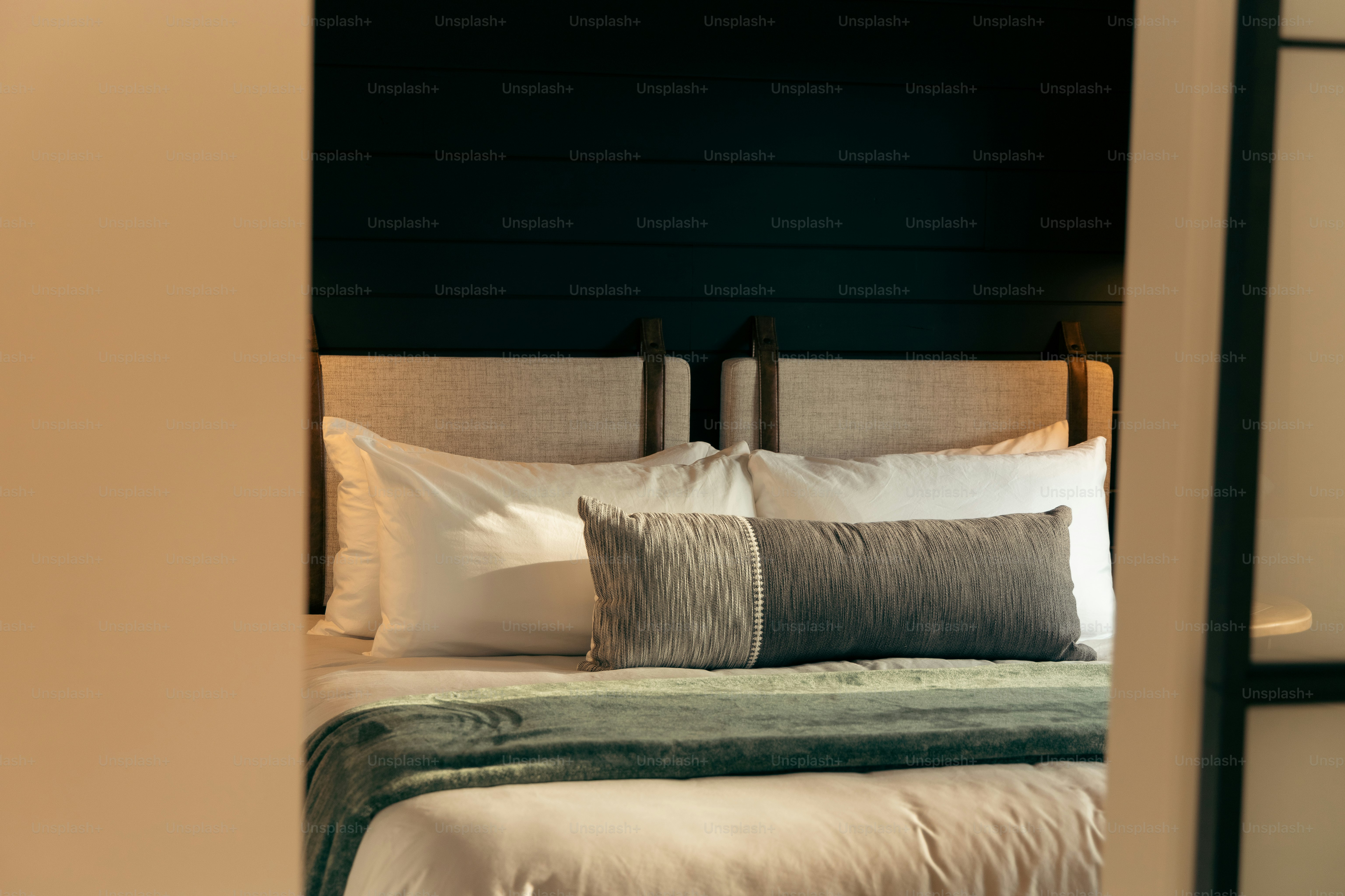 A bed with pillows and a blanket in a room photo Airbnb Image on Unsplash