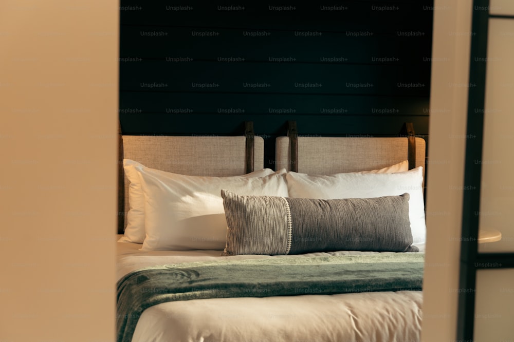 ein Bett mit Kissen und einer Decke in einem Zimmer