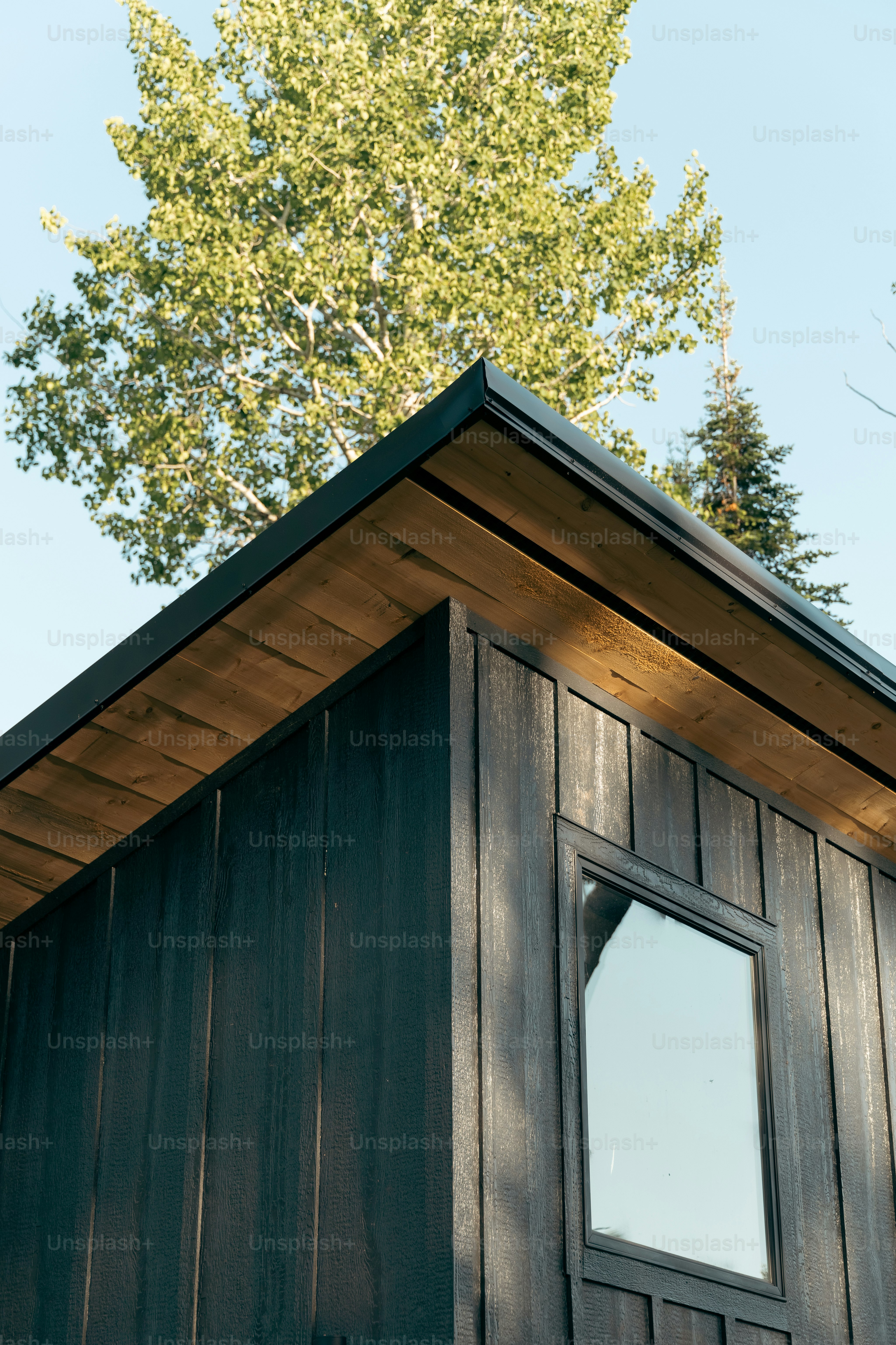 a wooden building with a tree in the background