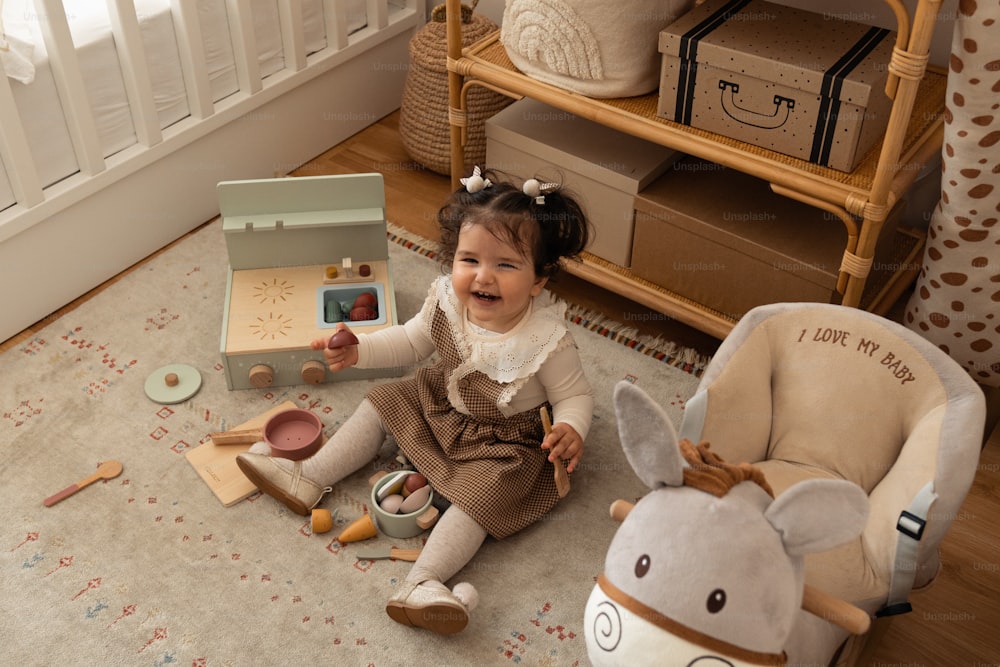 une petite fille assise par terre jouant avec des jouets