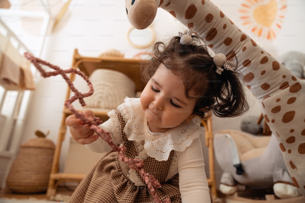 Una niña jugando con un juguete de jirafa