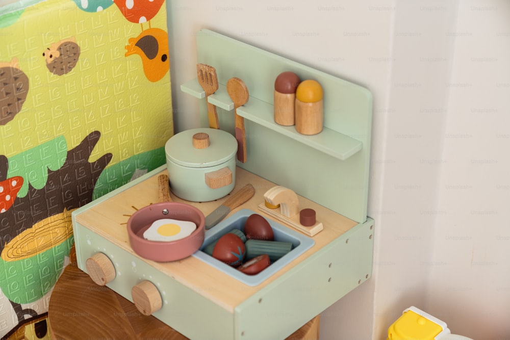 uma cozinha de brinquedo com fogão de madeira e utensílios de madeira