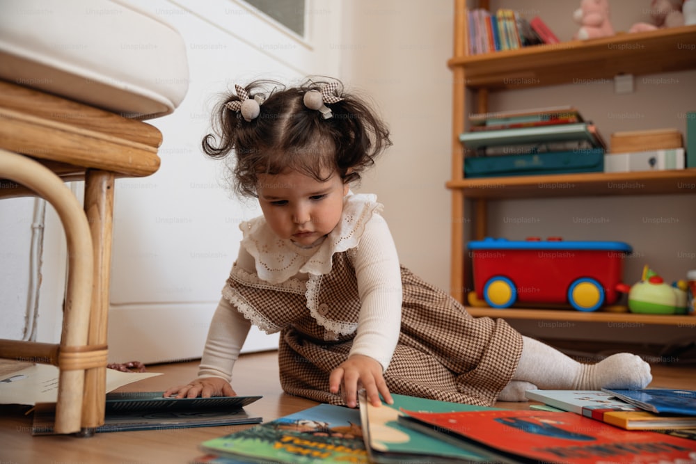 Uma menina está brincando com livros no chão