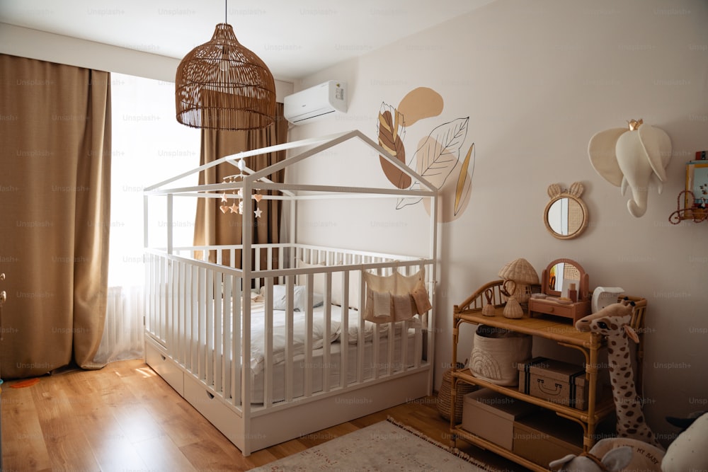하얀 유아용 침대와 나무 바닥이 있는 아기 방