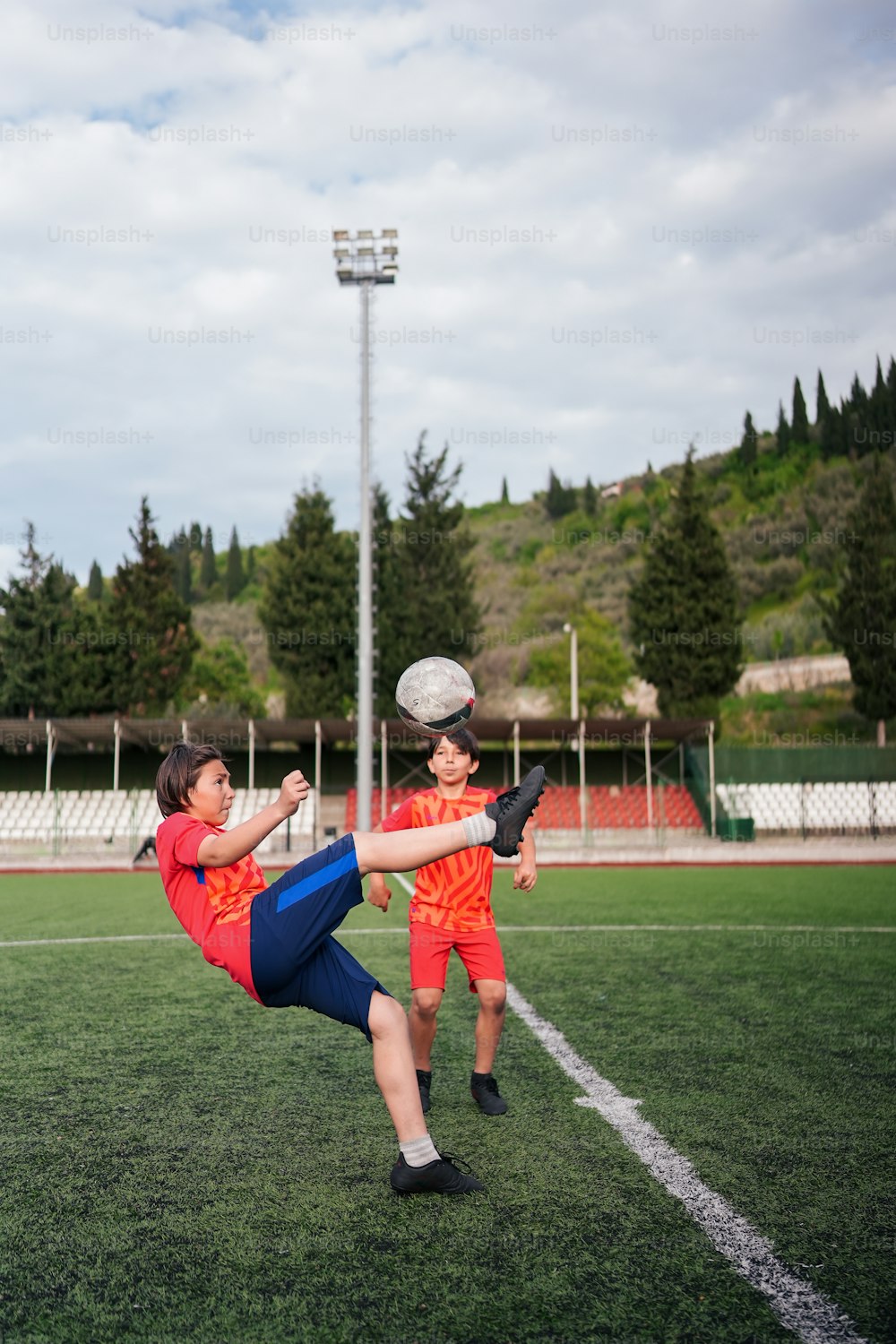 두 젊은이가 들판 위에서 축구공을 차고 있다