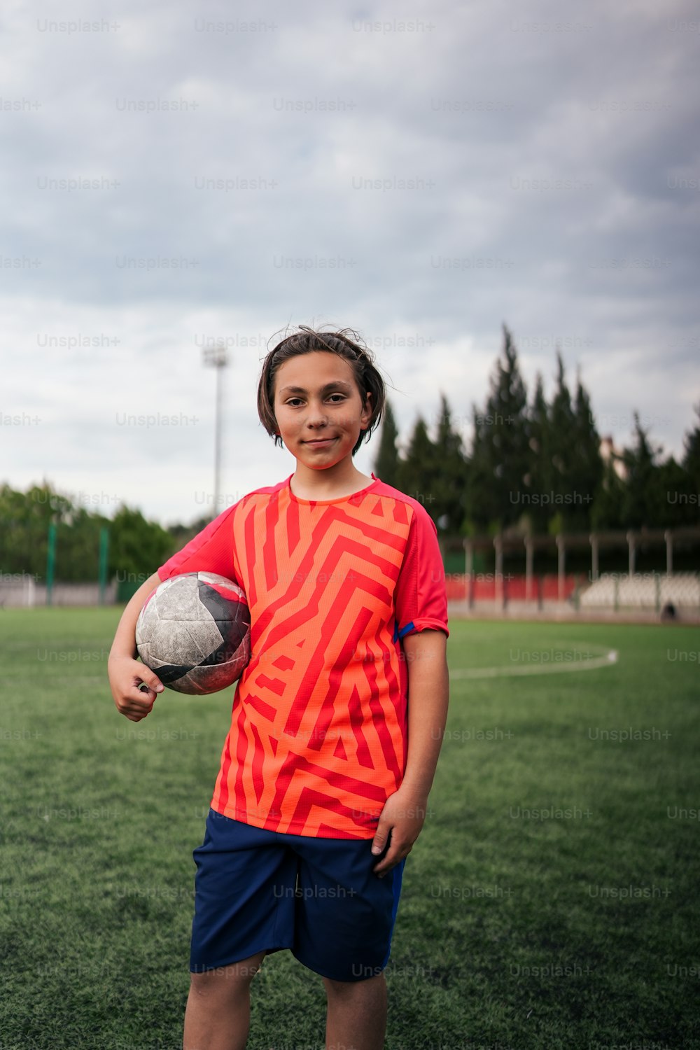 Un jeune garçon tenant un ballon de soccer sur un terrain
