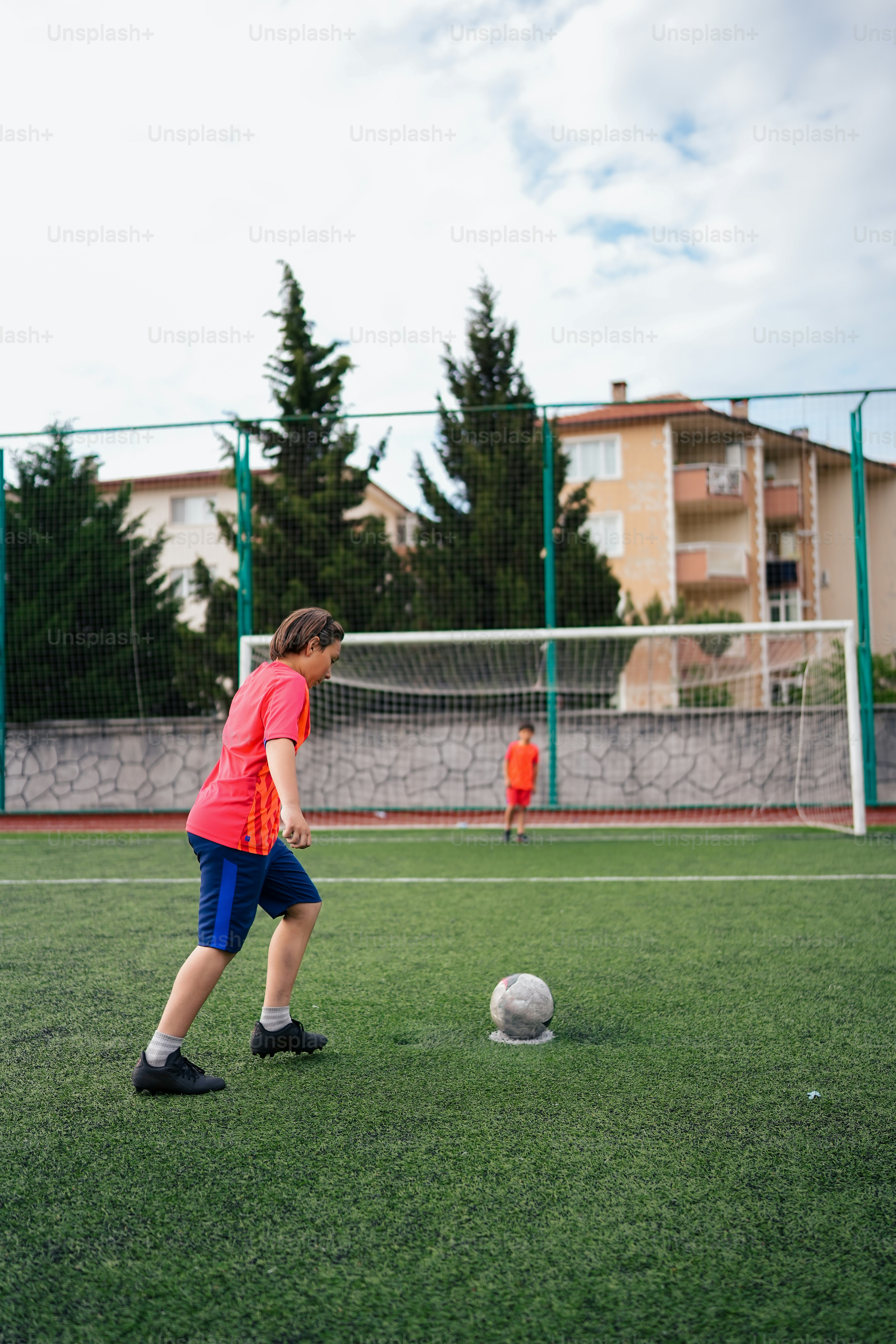 a young boy is kicking a soccer ball