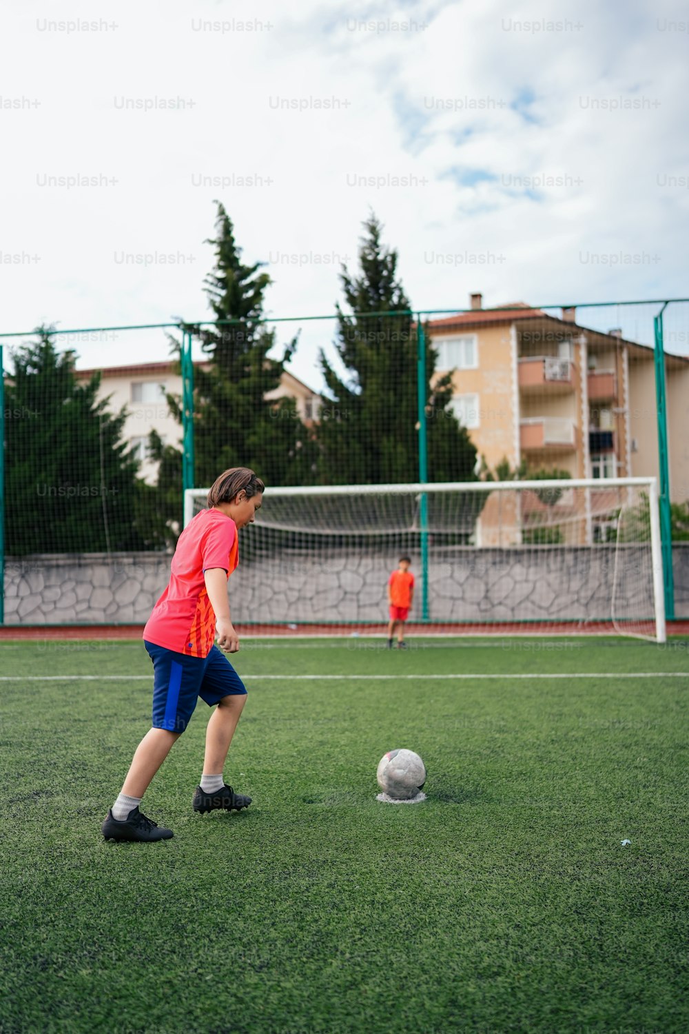 Ein kleiner Junge tritt gegen einen Fußball