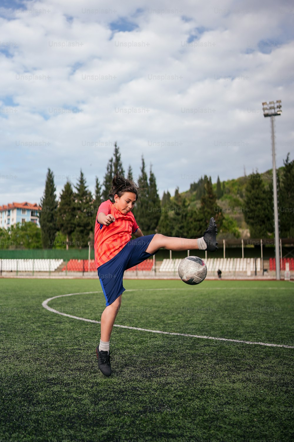 Jogadores de futebol adolescentes chutando bola de futebol campo