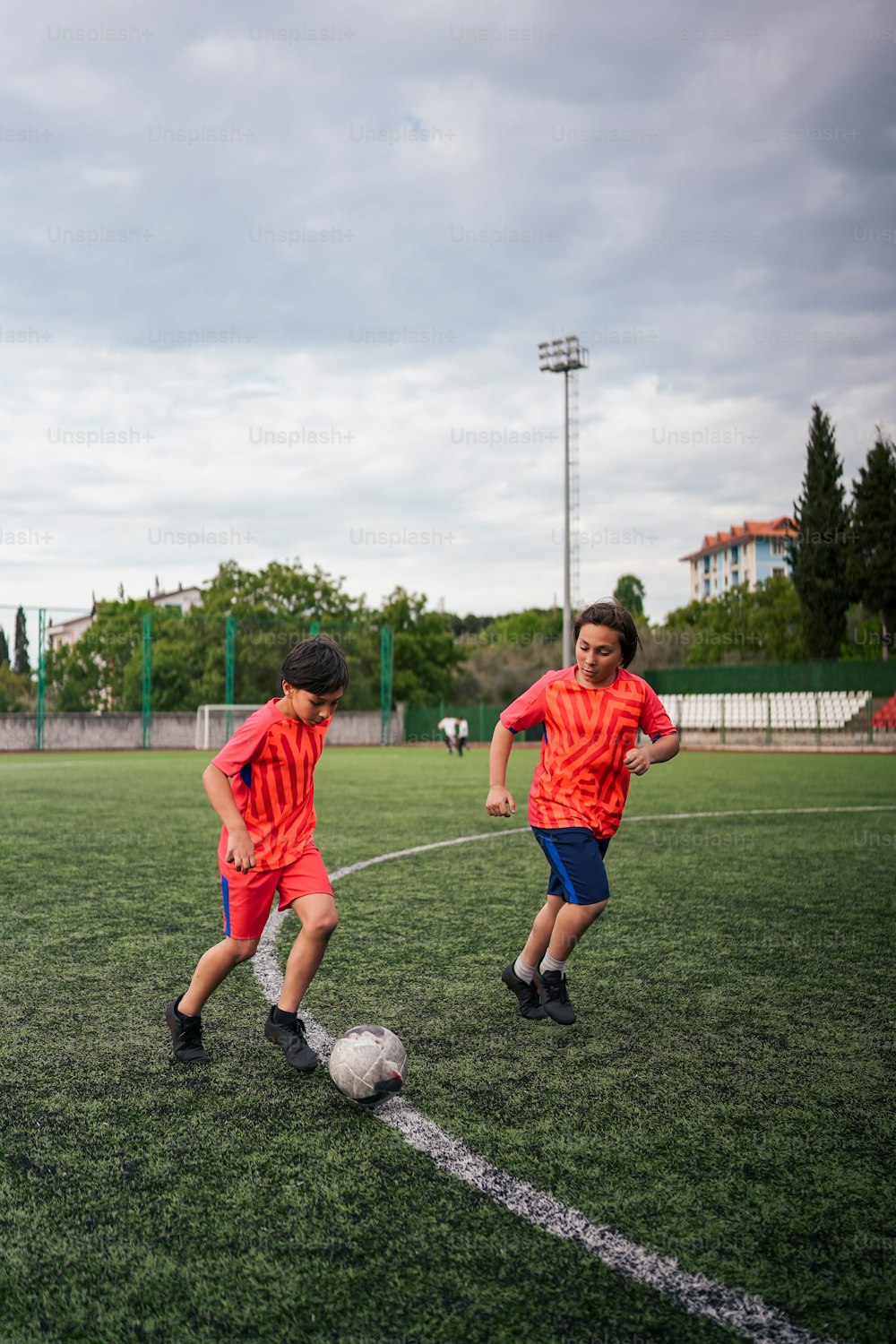 Un par de jóvenes pateando una pelota de fútbol