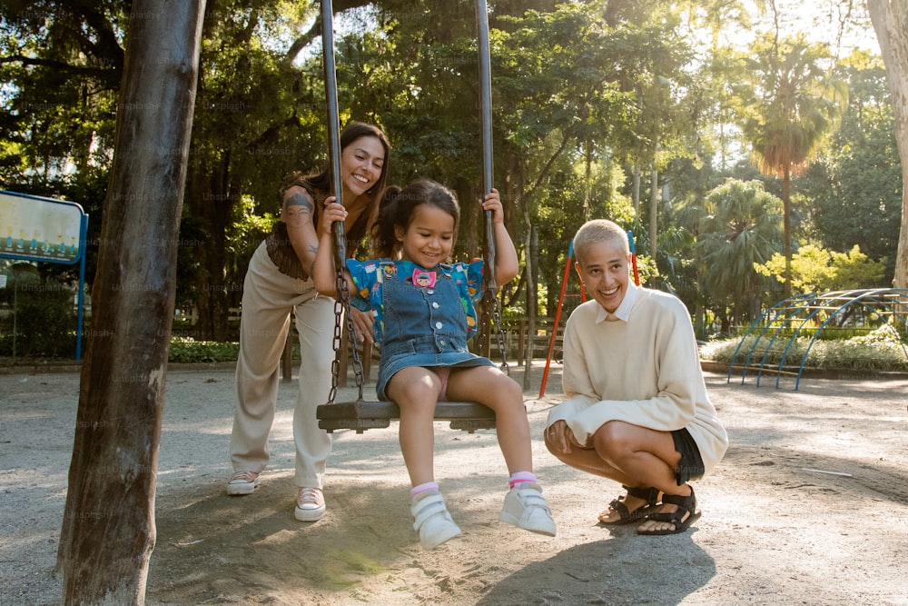 an older man and two young girls sitting on a swing