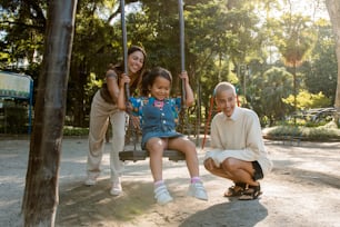 an older man and two young girls sitting on a swing