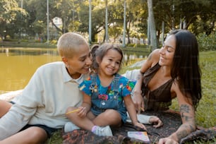 a woman and two children sitting on a blanket