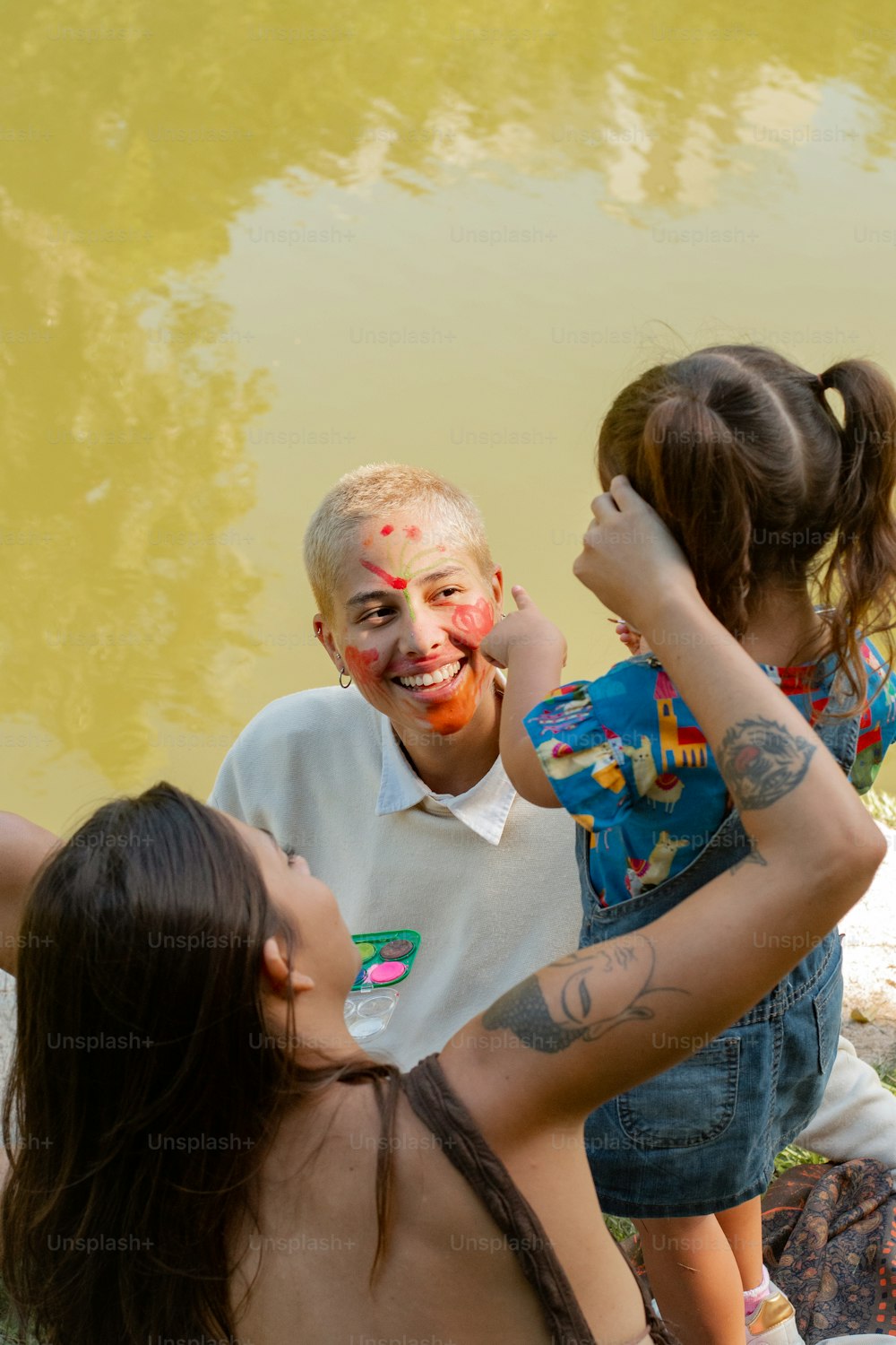 um homem e duas raparigas com pintura facial