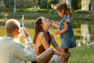 a woman is feeding a little girl a piece of cake