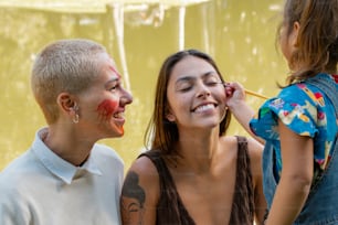 Una mujer y dos niños con la cara pintada