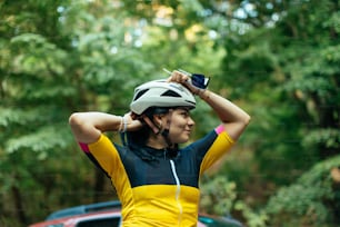 uma mulher de camisa amarela e preta com um capacete de bicicleta
