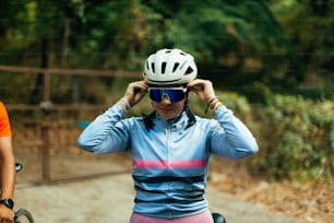 a woman wearing a helmet while standing next to a man