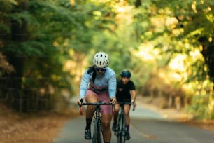 a couple of people riding bikes down a road