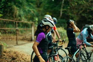 a group of people riding bikes down a dirt road