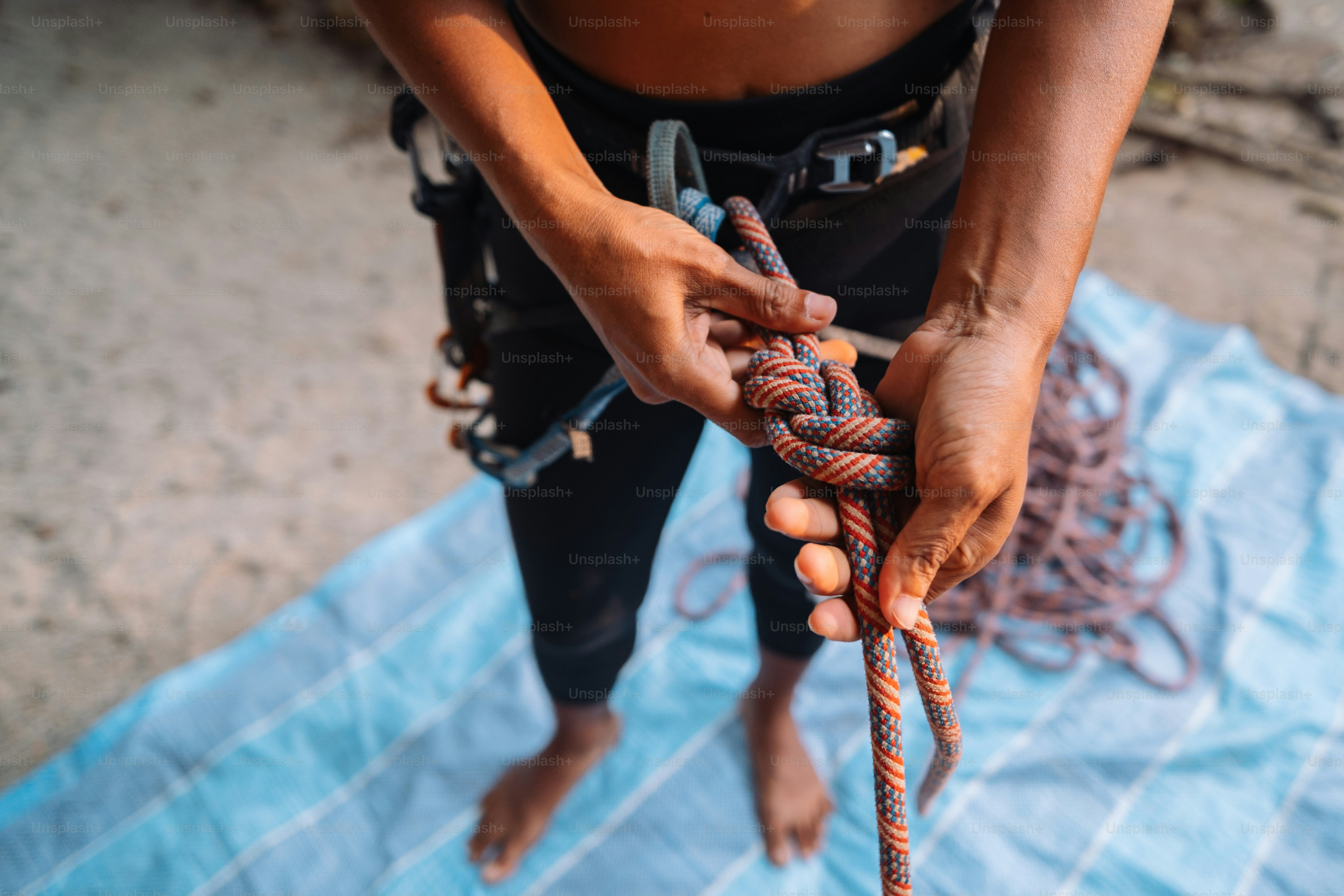 a person holding a rope on top of a blanket